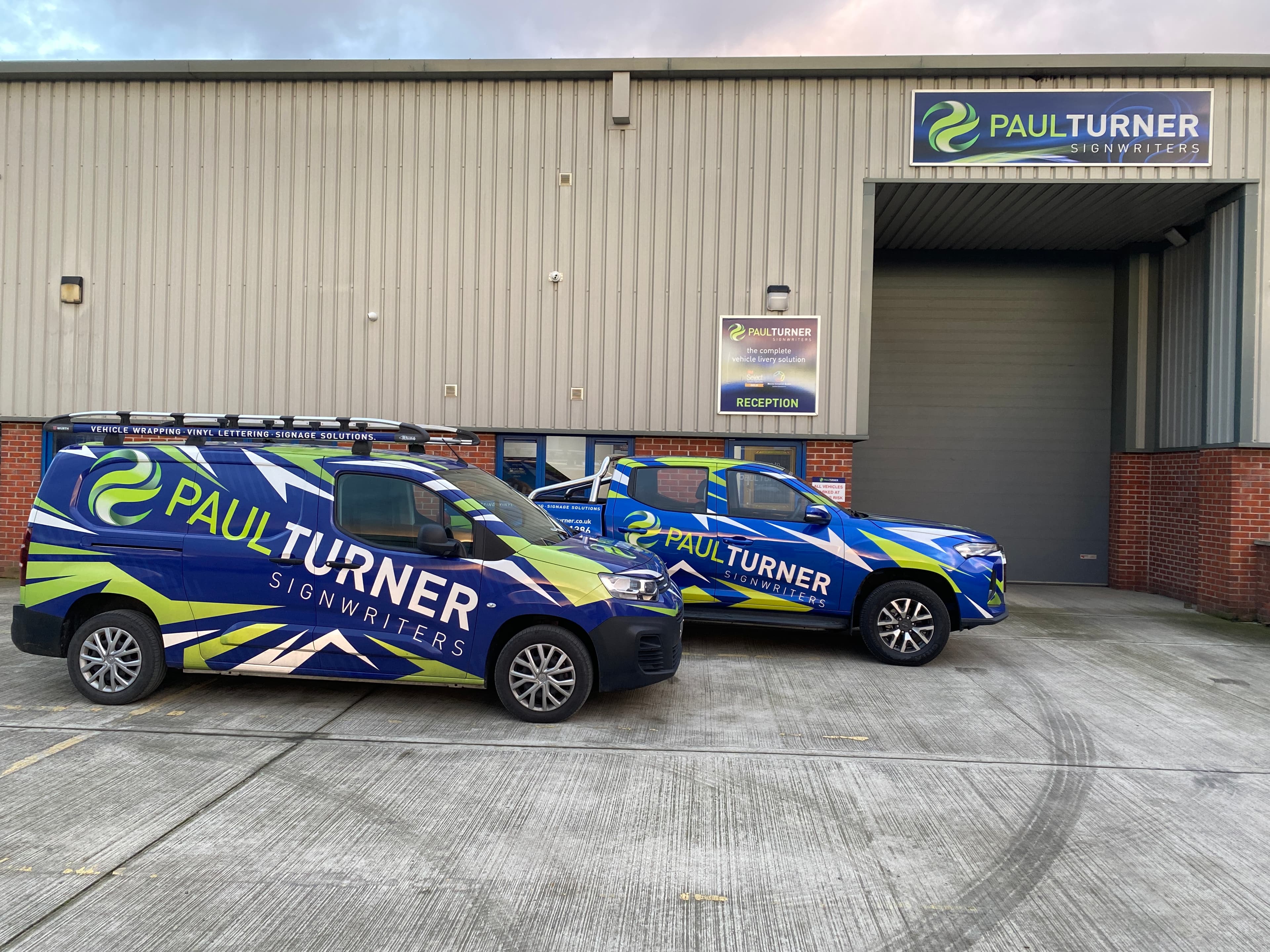 Paul Turner Signwriters company vans parked outside workshop.